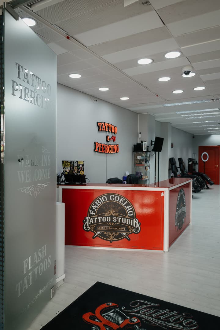 Reception counter and the Fábio Coelho Tattoo Studio crest
