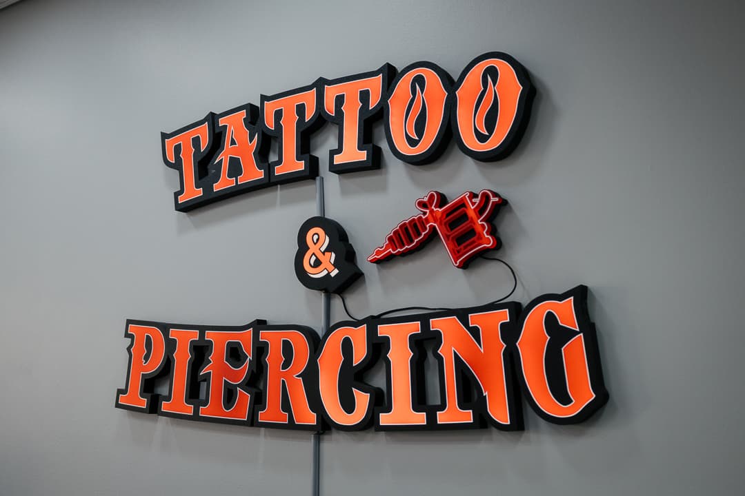 The Tattoo & Piercing sign on the studio wall